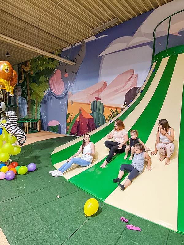 Kinder vergnügen sich auf einer Rutsche auf einem Indoor-Spielplatz in Augsburg.